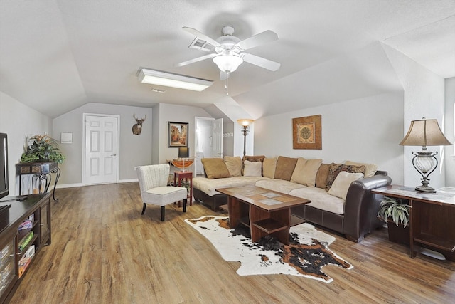 living room featuring lofted ceiling, ceiling fan, baseboards, and wood finished floors