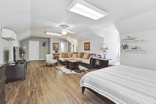 bedroom featuring a wall unit AC, a ceiling fan, vaulted ceiling, and wood finished floors