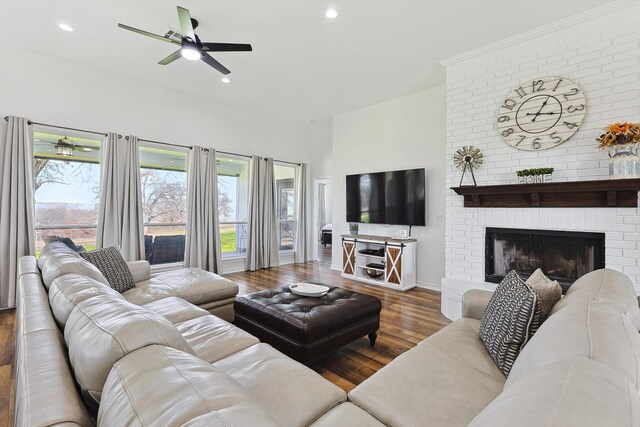 living area featuring a brick fireplace, wood finished floors, baseboards, recessed lighting, and a ceiling fan