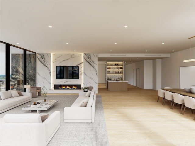 living room featuring a high end fireplace and light wood-type flooring