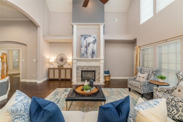 living room featuring a tile fireplace, ceiling fan, high vaulted ceiling, dark hardwood / wood-style floors, and ornamental molding