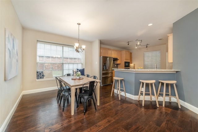 dining room with a notable chandelier and dark hardwood / wood-style flooring