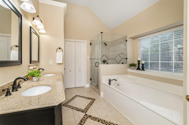 bathroom with tile patterned floors, vanity, shower with separate bathtub, and vaulted ceiling