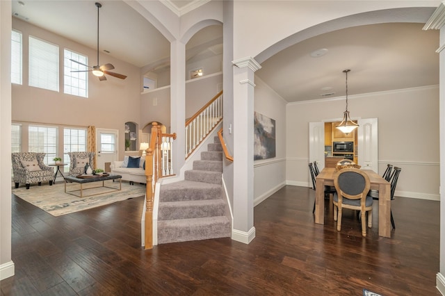 dining space featuring ceiling fan, dark hardwood / wood-style flooring, ornate columns, and ornamental molding