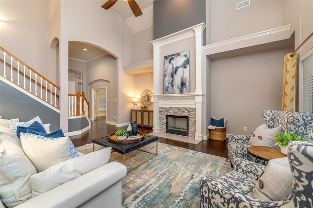 living room featuring dark hardwood / wood-style floors, ceiling fan, ornamental molding, and high vaulted ceiling