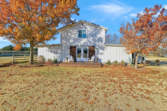 rear view of house featuring a deck, a yard, and french doors