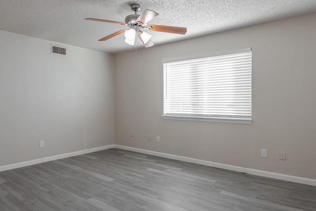 unfurnished room with ceiling fan, wood-type flooring, and a textured ceiling