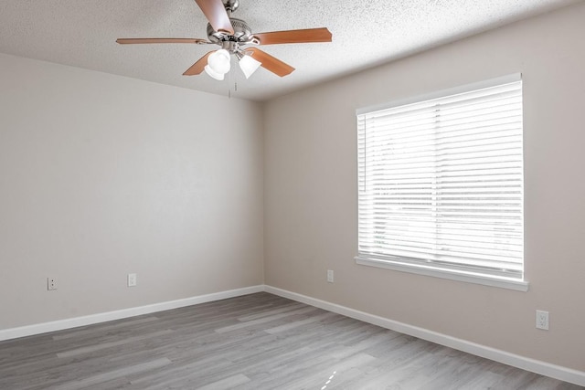 empty room featuring hardwood / wood-style floors, ceiling fan, and a textured ceiling