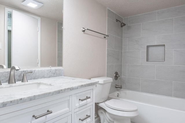 full bathroom with vanity, toilet, a textured ceiling, and tiled shower / bath