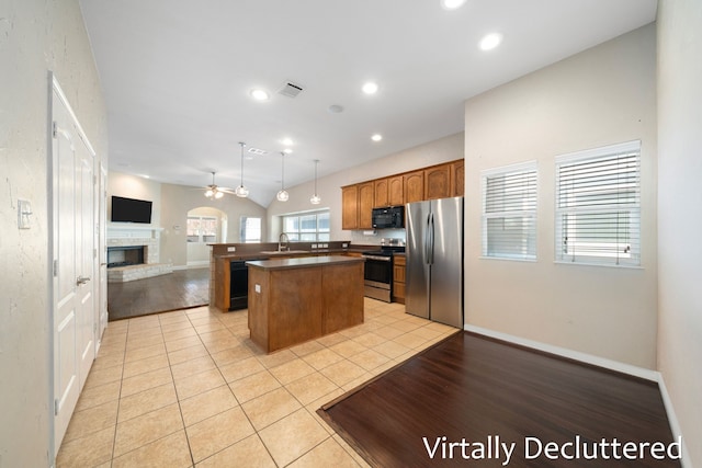 1125 Appalachian Ln, Savannah, TX 76227 - kitchen with black appliances, open floor plan, a sink, dark countertops, and a kitchen island