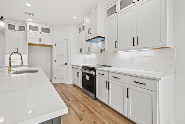 kitchen with white cabinets, pendant lighting, stainless steel electric range oven, and sink