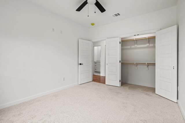 unfurnished bedroom with ceiling fan, a closet, and light carpet