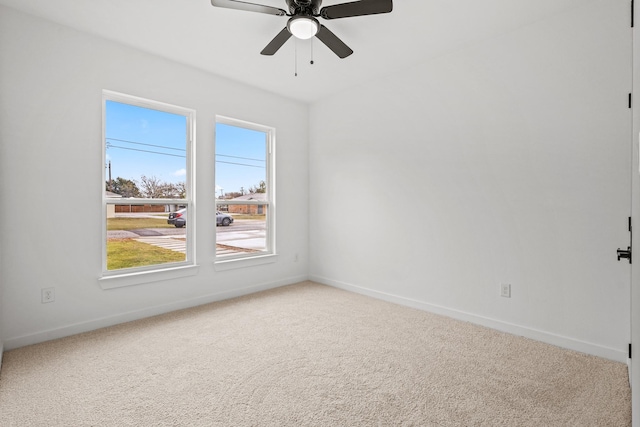 carpeted empty room with ceiling fan and plenty of natural light