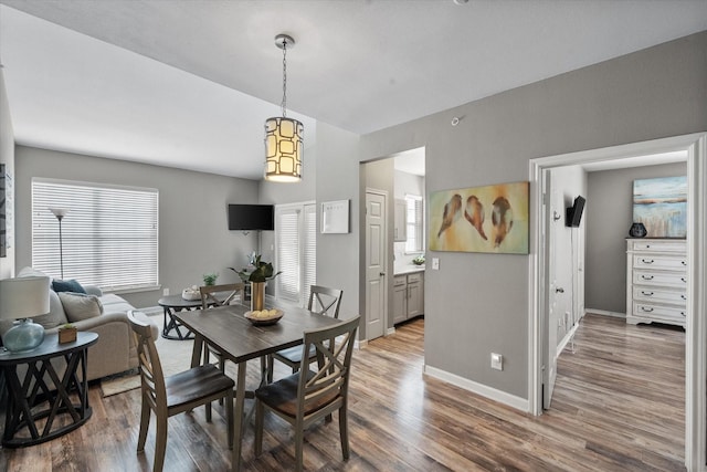 dining area featuring lofted ceiling and hardwood / wood-style flooring