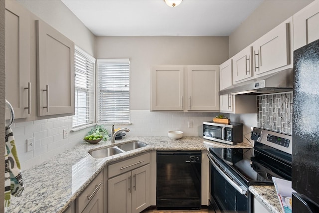 kitchen with sink, backsplash, black appliances, and light stone countertops