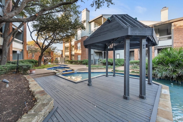 view of swimming pool with a gazebo and an in ground hot tub