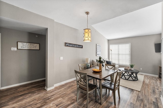 dining area with vaulted ceiling and dark wood-type flooring