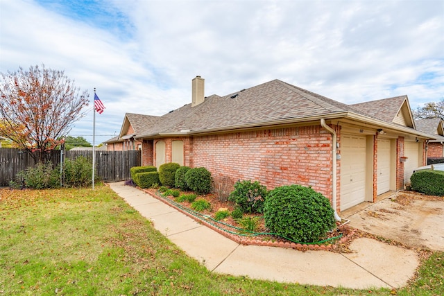 view of home's exterior with a garage and a lawn