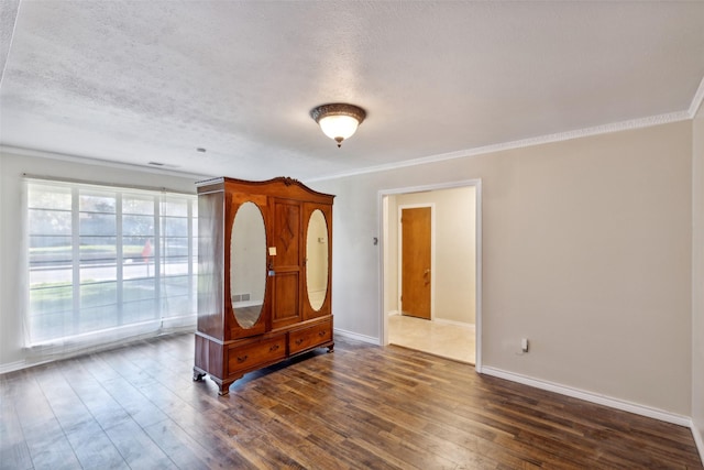 interior space featuring ornamental molding, dark hardwood / wood-style floors, and a textured ceiling