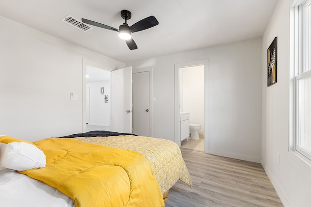 bedroom with light hardwood / wood-style floors, ensuite bath, and ceiling fan