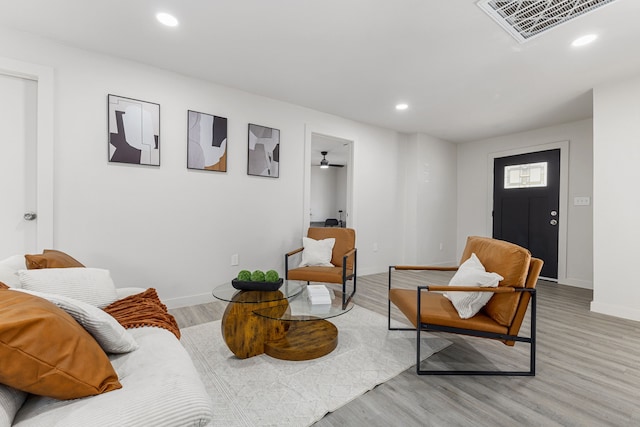 living room with ceiling fan and light hardwood / wood-style floors