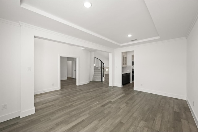 interior space with crown molding, dark hardwood / wood-style floors, and a raised ceiling