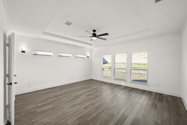 unfurnished room featuring dark hardwood / wood-style flooring, a wall unit AC, a raised ceiling, ornamental molding, and ceiling fan