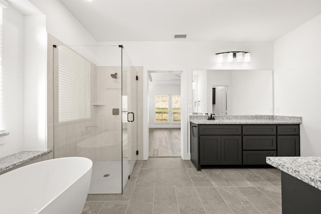 bathroom with plus walk in shower, tile patterned flooring, and vanity