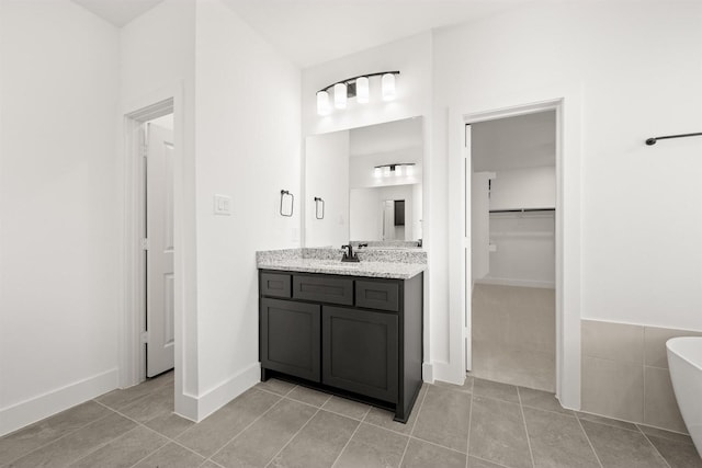 bathroom featuring a washtub, tile patterned floors, and vanity