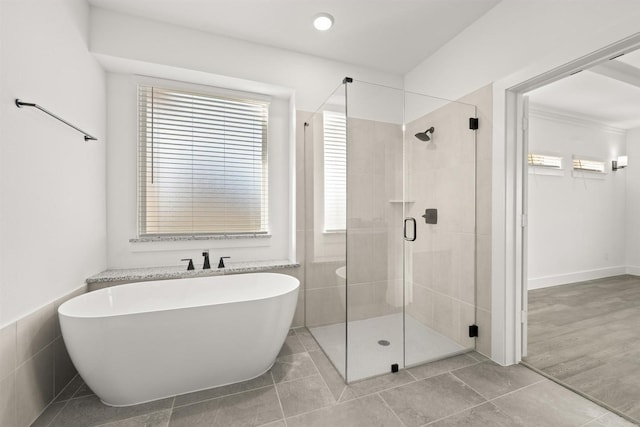 bathroom featuring shower with separate bathtub