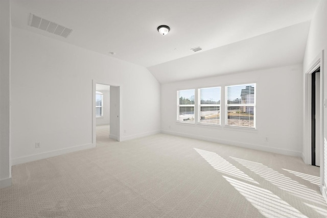 unfurnished room featuring lofted ceiling and light carpet