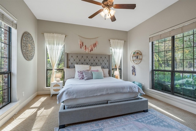 carpeted bedroom with multiple windows and ceiling fan