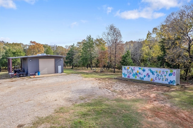 view of yard featuring a garage and an outbuilding