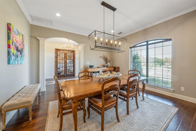 dining room featuring dark hardwood / wood-style floors, ornamental molding, and decorative columns