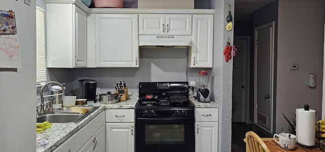 kitchen featuring black gas stove, white cabinetry, and sink