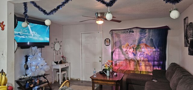 living room with ceiling fan, hardwood / wood-style floors, and a textured ceiling