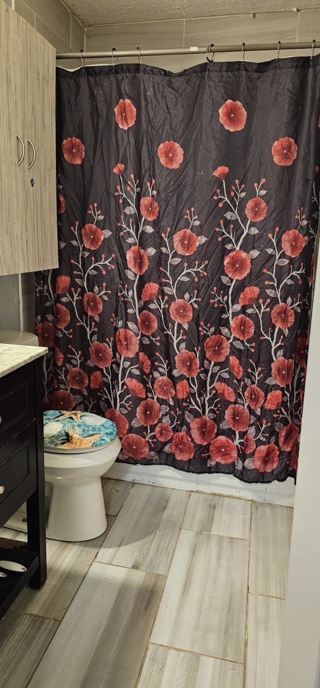 bathroom with wood-type flooring, vanity, and toilet