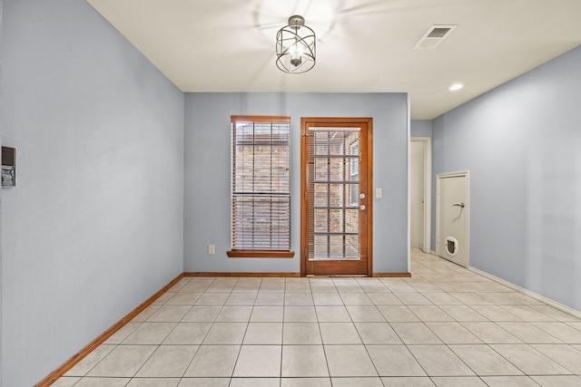unfurnished room featuring light tile patterned floors, visible vents, and baseboards