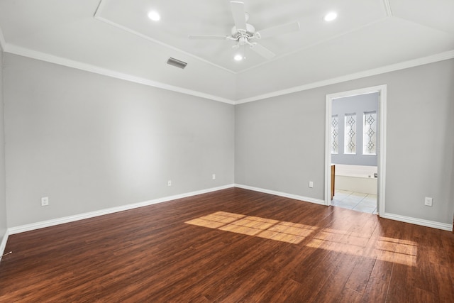 spare room with visible vents, wood finished floors, ornamental molding, and a ceiling fan