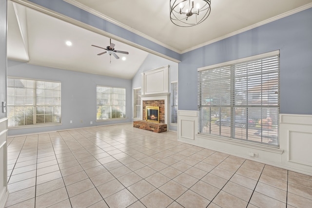 unfurnished living room featuring crown molding, light tile patterned flooring, a fireplace, and wainscoting