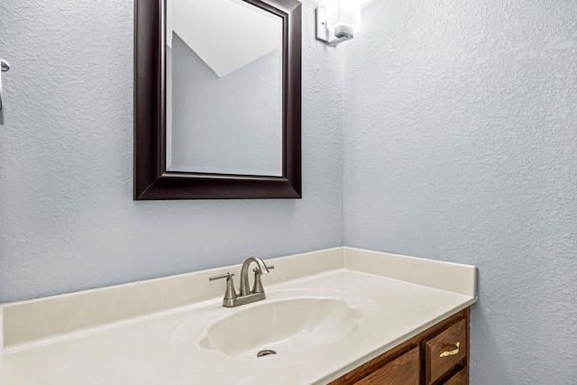 bathroom featuring vanity and a textured wall