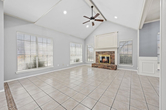 unfurnished living room with beamed ceiling, plenty of natural light, a fireplace, and ceiling fan