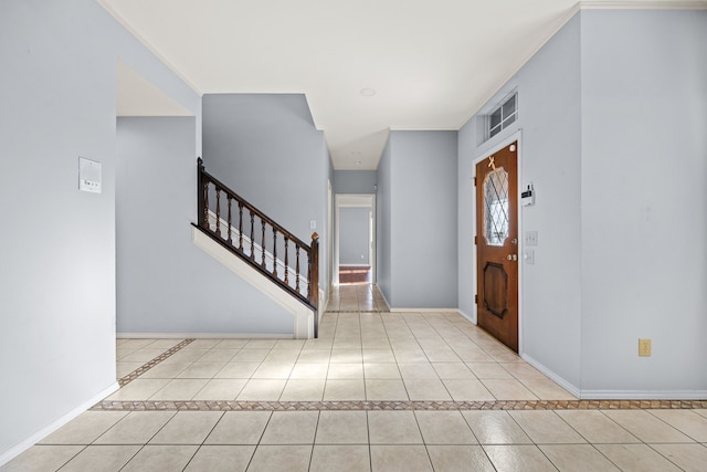 tiled entrance foyer featuring stairs and baseboards