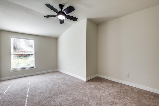 carpeted empty room with ceiling fan and lofted ceiling