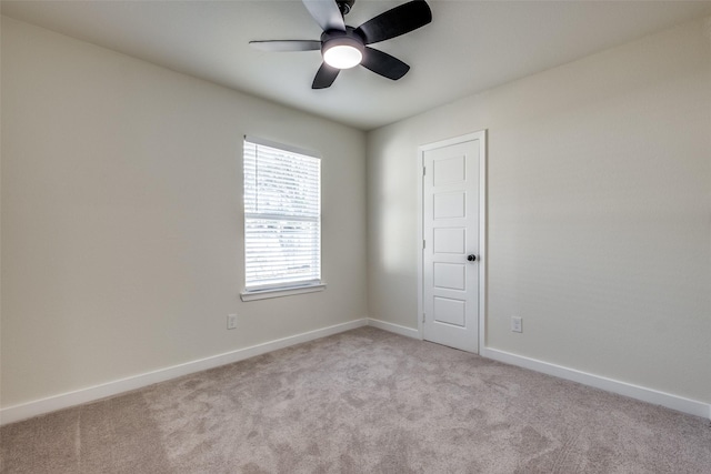 spare room featuring light carpet and ceiling fan