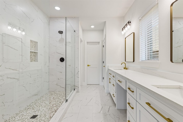 bathroom with a tile shower and vanity