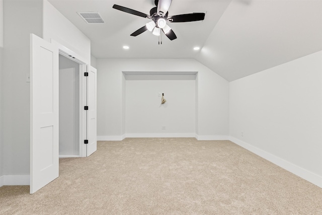 additional living space with ceiling fan, light colored carpet, and vaulted ceiling