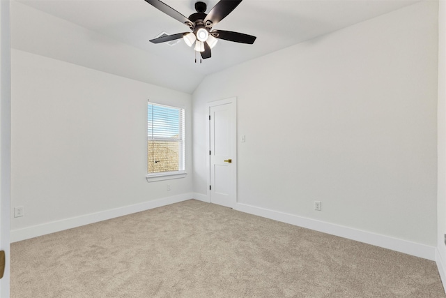 carpeted spare room featuring ceiling fan and vaulted ceiling