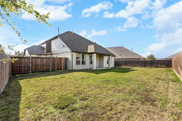 rear view of house with a lawn and a patio