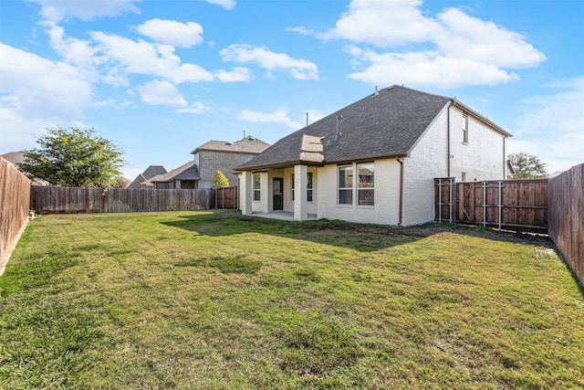 back of property with a lawn and a patio